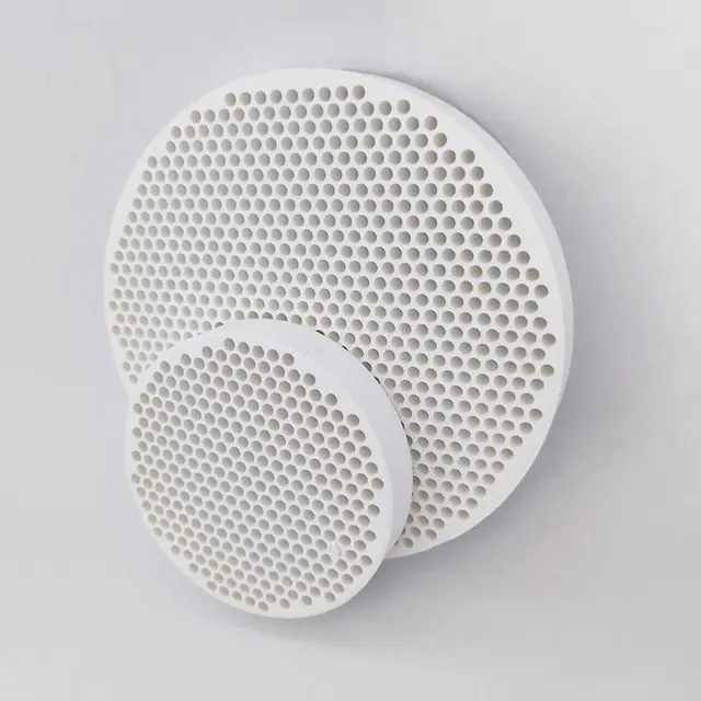 Ceramic foundry filter held up so its open-cell porosity is visible